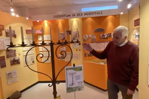 Werner Rasche neben einem schmiedeeisernen Chanukkaleuchter, der bei der Schändung der Synagoge in Rockenhausen in der Pogromnac