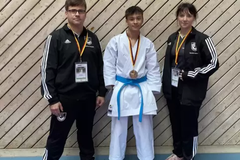 Karateka Sebastian Becker mit Landestrainer Marcus Gutzmer und Assistenz-Landestrainerin Sandra Gutzmer. 