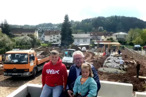 Bürgermeister Thomas Peifer und seine Enkel Paul und Klara auf der künftigen Terrasse am Dorfgemeinschaftshaus. Die wird fertigg