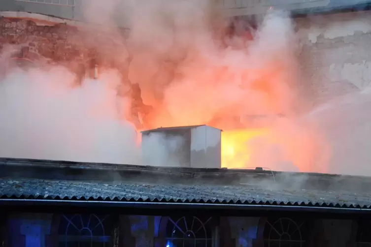 Das Feuer bricht im Dachbereich der Fabrik durch.