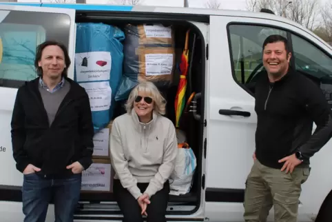 Barbara Aldorf mit Torsten Wolf (links) und Martin Schüler am vollbepackten Transporter kurz vor der Abfahrt in Zweibrücken.