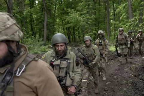  Ukrainische Soldaten gehen in der Nähe eines kürzlich zurückeroberten Dorfes nördlich von Charkiw in der Ostukraine durch den W