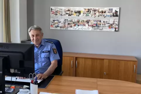 Uwe Becker an einem seiner letzten Arbeitstage in seinem Büro. An der Wand im Hintergrund eine „Zeitreise seines Arbeitslebens“.