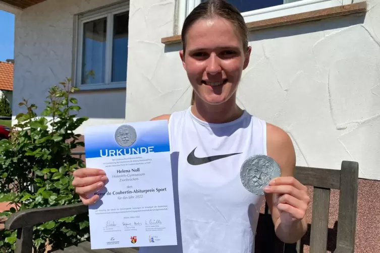 Stolz präsentiert Helena Noll aus Großsteinhausen Urkunde und Medaille des Pierre de Coubertin-Abiturpreises Sport.