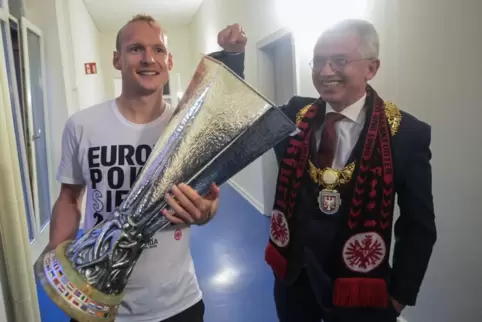 Eitelkeit &NarzissmusDa hält Eintracht-Kapitän Sebastian Rode den Pokal noch in der Hand. Aber OB Peter Feldmann will schon zupa