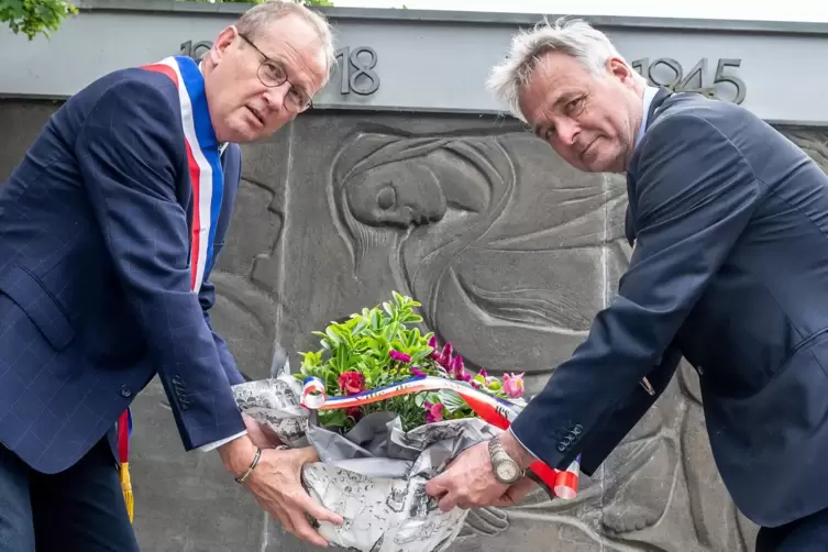 Stellten Blumen ans Kriegerdenkmal: die Bürgermeister Jean Claude Lagrange (links) und Peter Funck.