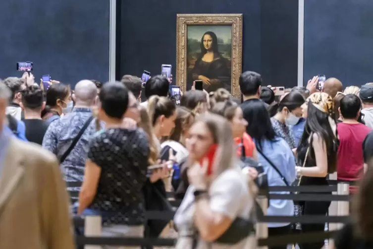 Besucher warten in einer Schlange vor der Mona Lisa im Louvre. 