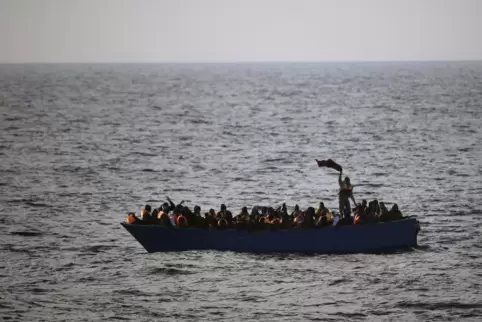 Mittelmeer: Flüchtlinge winken aus einem etwa 21 Meilen vor dem libyschen Sabratha schwimmenden Holzboot. 