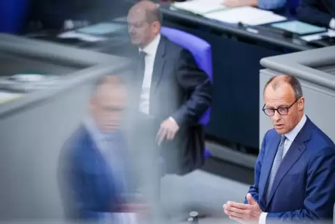 Der Oppositionschef Friedrich Merz und sein Schatten. Im Hintergrund: Olaf Scholz. 