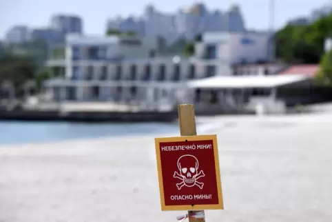 Ein Schild warnt vor Landminen an einem Strand in Odessa. Das Räumen der Minen müsste vor der Verschiffung der Millionen Tonnen 