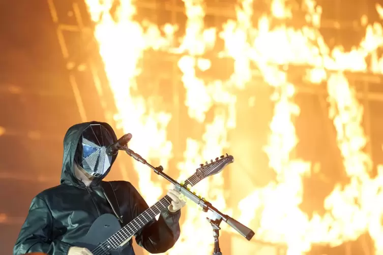 Muse waren Headliner am Samstagabend und starteten mit futuristischen Masken und einem brennenden Band-Logo im Hintergrund.