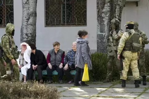 Ältere Anwohner sprechen mit einer Gruppe russischer Soldaten. Die Region Cherson steht seit den ersten Tagen der russischen Mil