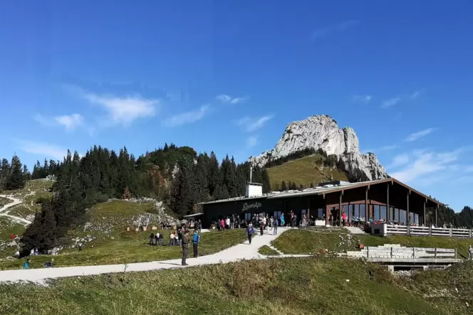 Eine Berghütte mit einem Gipfel im Hintergrund.