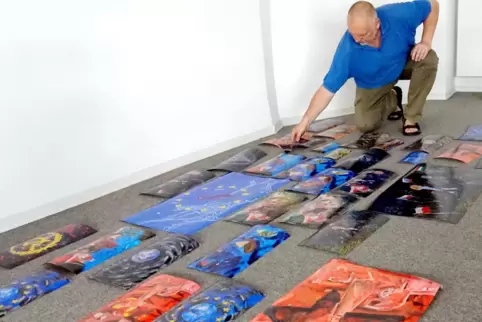 Stefan Budian legt einige der 4300 Malschritte auf dem Boden, um sie als großes Puzzle an die Wand zu pinnen. 