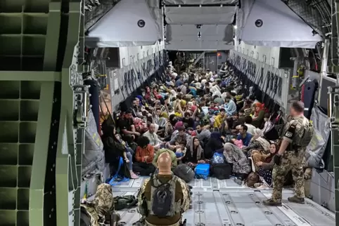 Dicht gedrängt sitzen im August vorigen Jahres Menschen, die aus Kabul ausgeflogen wurden, auf dem Boden eines Transportflugzeug