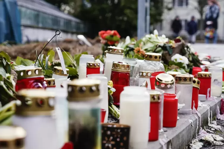 Kerzen und Blumen für die getöte Studentin liegen vor einem Universitätsgebäude.