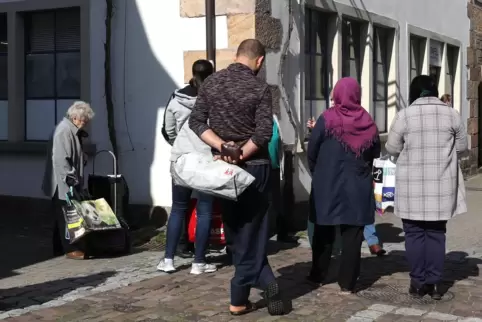 Menschen warten vor der Tafel in Bad Bergzabern. Die Vorsitzenden der Tafeln Südpfalz befürchten, dass es bald noch mehr werden 