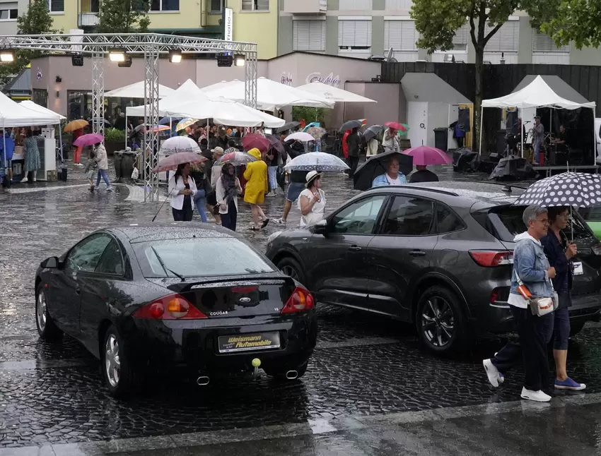 Ohne Schirm ging gar nichts am Freitag: Blick auf den Rathausplatz, wo neue und ältere Modelle verschiedener Automarken zu bewun