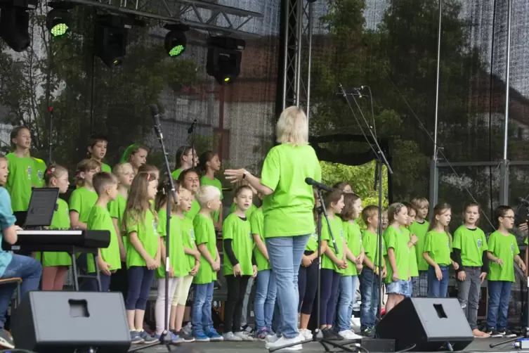 40 Kinder in knalligem Grün: der neue Kinderchor „Ethno-Chor-Kids“ mit Leiterin Verena Dreschwer singt am Sonntagnachmittag gesc