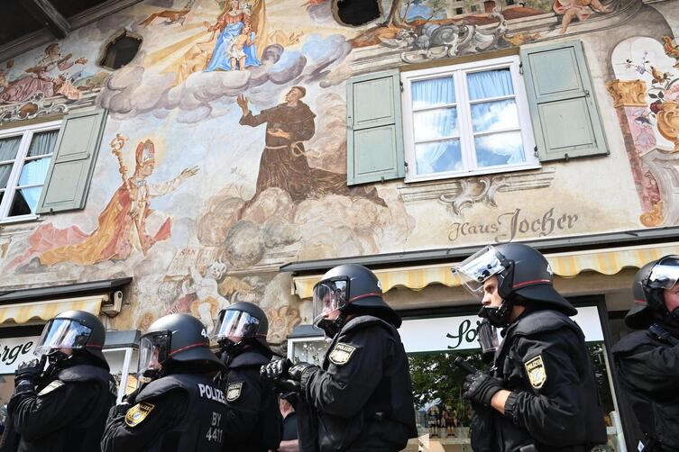 Polizisten vor einem mit Lüftlmalerei verzierten Haus in Garmisch-Partenkirchen.