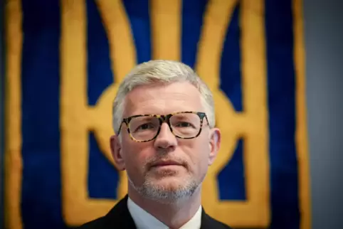 Andrij Melnyk vor dem Wappen der Ukraine im Botschaftsgebäude in Berlin.