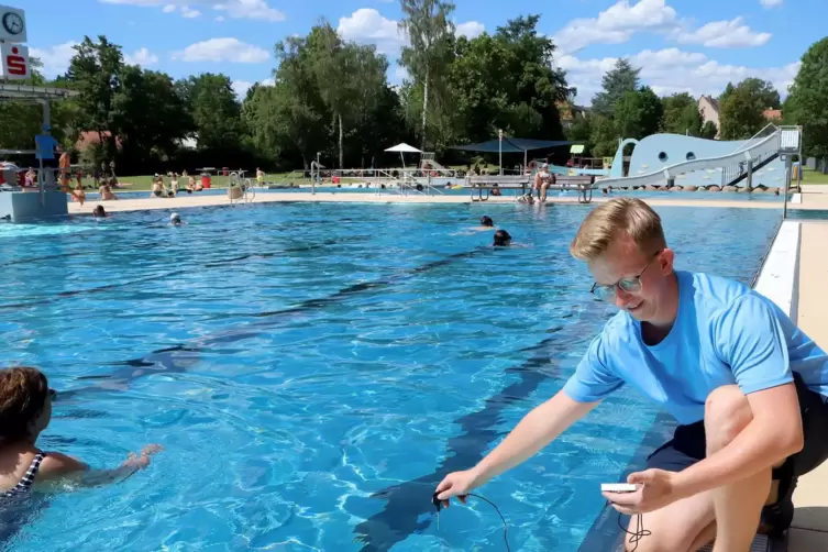 Schwimmmeister Dirk Ehresmann misst die Wassertemperatur im Freibad. 