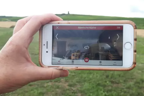 Rundgang durch die Palastvilla: Mittels App und Handy oder Tablet können Besucher auf einer Wiese bei Mauchenheim in die Römerze