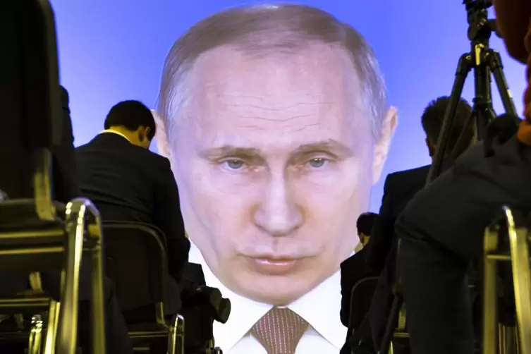 Journalisten aus aller Welt lauschen in Moskau den Ausführungen Wladimir Putins, der über Video zugeschaltet ist. 