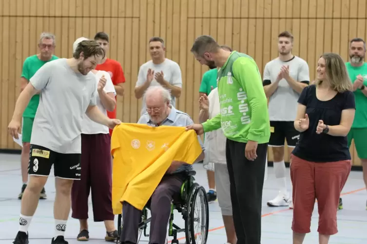 SV-Spieler Philipp Hammann (links) und VTZ-Torwart Norman Dentzer &uuml;berreichen Fritz Sch&auml;fer vor dem Benefizspiel ein Trikot mit 
