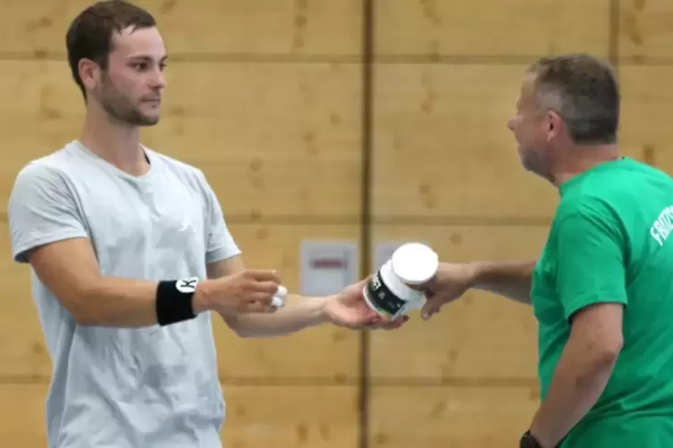 Keine gute Idee: SV-Handballer Tom Grieser (links) reicht Fu&szlig;baller Helmut Emrich vom TuS Rimschweiler in der Pause die Harz-Dos