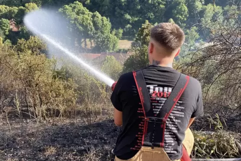 Ein Feuerwehrmann beim Löschen des Flächenbrandes in Neuleiningen am Montag. 