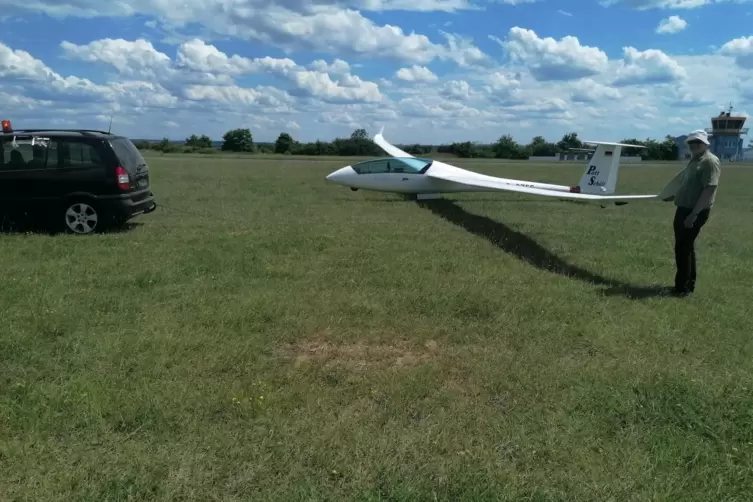 Nach der Landung: Dieter Schuhmann st&uuml;tzt die Tragfl&auml;che, w&auml;hrend der Duo Discus mit dem Spitznamen &bdquo;Pott Sch&uuml;tt&ldquo; per Auto zur&uuml;c