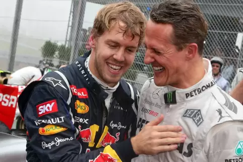 Konkurrenten und Freunde: Sebastian Vettel (links), der hier im November 2012 mit Michael Schumacher seinen dritten WM-Titel fei