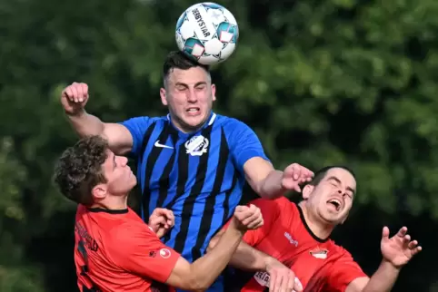 Der Geinsheimer Julian Herrmann (Mitte) setzt sich mit einem Kopfball gegen die Diedesfelder Nils Krämer (links) und Simon Tege 