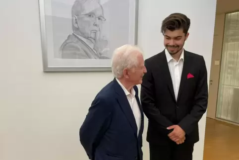 Nobelpreisträger Harald zur Hausen (li.) gezeichnet an der Wand und in natura davor zusammen mit dem Zeichner Cedric Gregor.