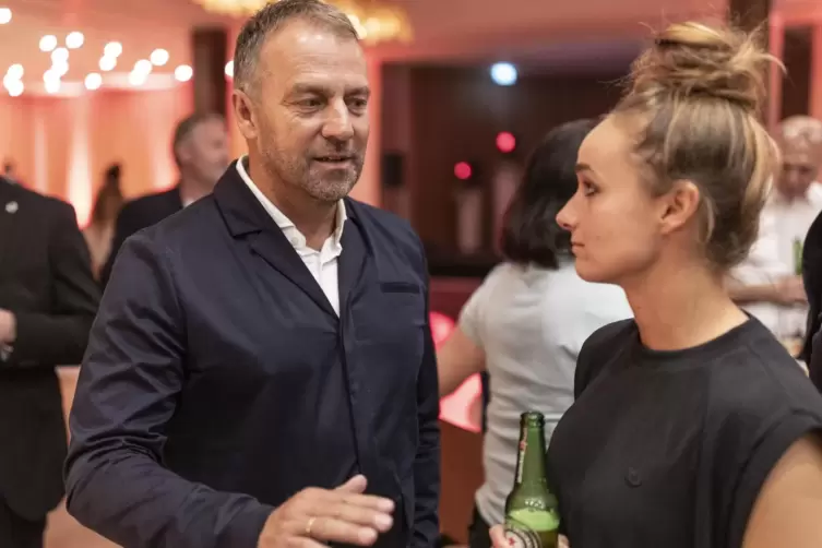 Trost vom M&auml;nner-Bundestrainer: Lina Magull mit Hansi Flick und Bierflasche beim abendlichen Bankett in London.