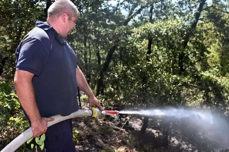 Mit dem Schlauch l&ouml;scht Feuerwehrmann Martin Galler gezielt einzelne Glutnester ab.