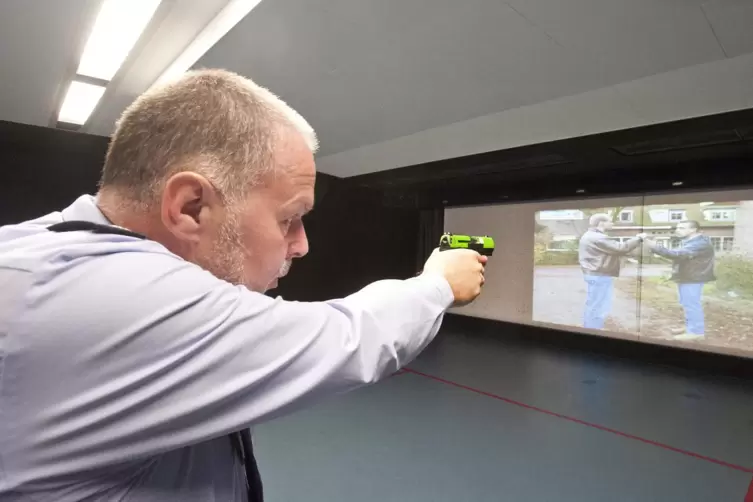 Der Profi: Schie&szlig;trainer Rainer K&ouml;llner feuert auf den Angreifer (auf der Leinwand rechts). 
