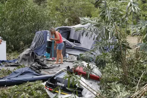  Eine Frau packt die Reste der zerstörten Zelte auf einem Campingplatz auf Korsika ein. 