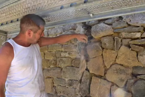 Bernd Busch zeigt, wie leicht sich Steinbröckchen aus der Burgmauer lösen. Im Zuge der Sanierung werden auch 30 Fledermaus-Apart