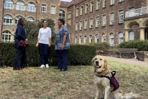 Von links: Katja Rull, Katharina Ottinger und Dr. Susanne Euler im Gespräch auf dem Klinik-Gelände. Hund Hannes (vorne) kommt zw