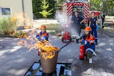 Unter der Aufsicht von Patrick Jäger und Leonie Will von der Freiwilligen Feuerwehr rücken die Kinder einem Brand zu Leibe.