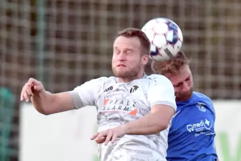 Mit geschlossenen Augen zum Ball: Marcus Schunk vom TuS Steinbach (im weißen Trikot) im Kopfballduell mit einem Spieler der TSG 