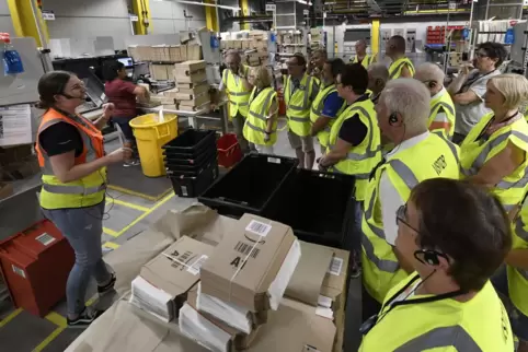 Welcher Artikel kommt in welchen Umschlag? Patricia Schade (links) erklärt den Besuchern den Verpackungsvorgang im Amazon-Logist Welcher Artikel kommt in welchen Umschlag? Patricia Schade (links) erklärt den Besuchern den Verpackungsvorgang im Amazon-Logist