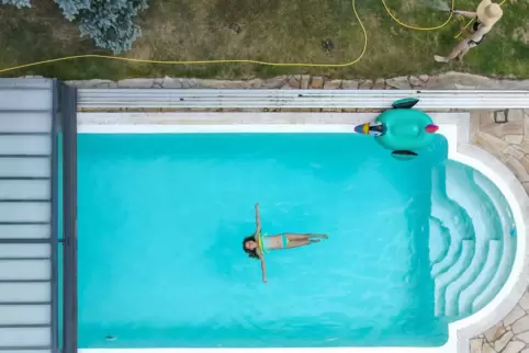  Ein Kind schwimmt in einem Pool. 