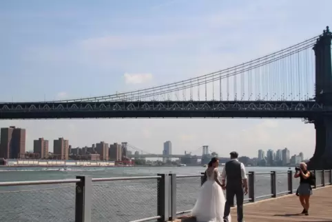 Annika Heisig und Patrick Brosch gehen nach ihrer Trauung am Pebble Beach im Brooklyn Bridge Park Hand in Hand für ein Erinnerun