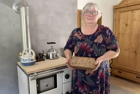 Claudia Klingner-Kaufmann mit Holzherd, Sägemehl-Brikett, Wasserkesseln und Bügeleisen. 