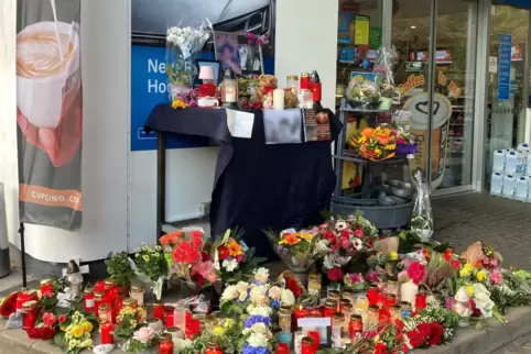 Blumen und Kerzen sind vor einer Tankstelle aufgestellt. Ein junger Kassierer war am 18. September 2021 von einem mit einer Pist