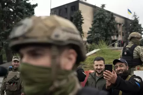 Der ukrainische Präsident Selenskyj (Mitte) macht in der zurückeroberten Stadt Isjum ein Selfie mit einem Polizisten. 