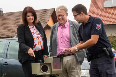 Die Bürgermeister Sabine Wienpahl (Kibo) und Bernd Frey (Eisenberg) lassen sich die Blitzanlage von Dennis Kandziora (rechts) vo